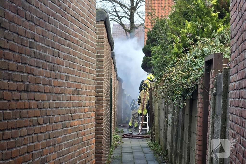 Vlammen, explosies en zwarte rook bij brand achter woning