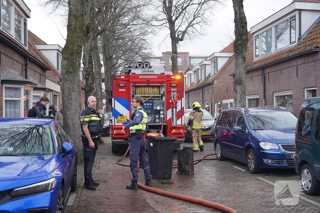 Vlammen, explosies en zwarte rook bij brand achter woning