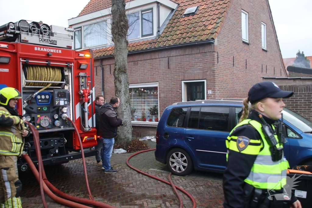 Vlammen, explosies en zwarte rook bij brand achter woning