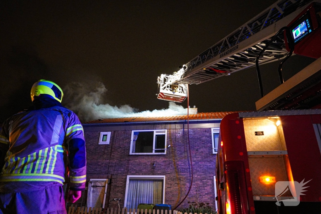 Rookwolken stijgen uit dak van woning