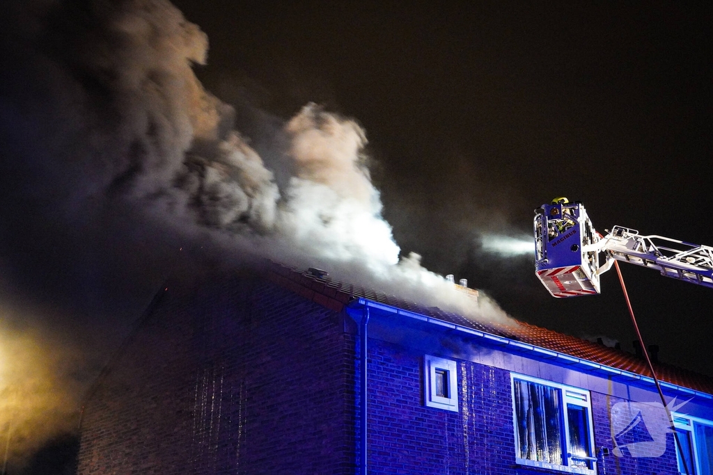 Rookwolken stijgen uit dak van woning