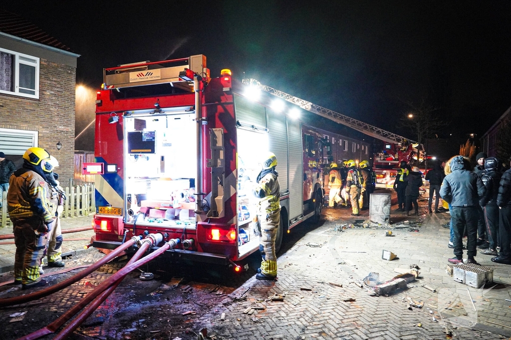 Rookwolken stijgen uit dak van woning