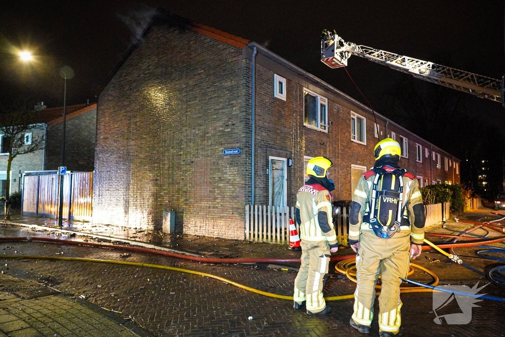 Rookwolken stijgen uit dak van woning