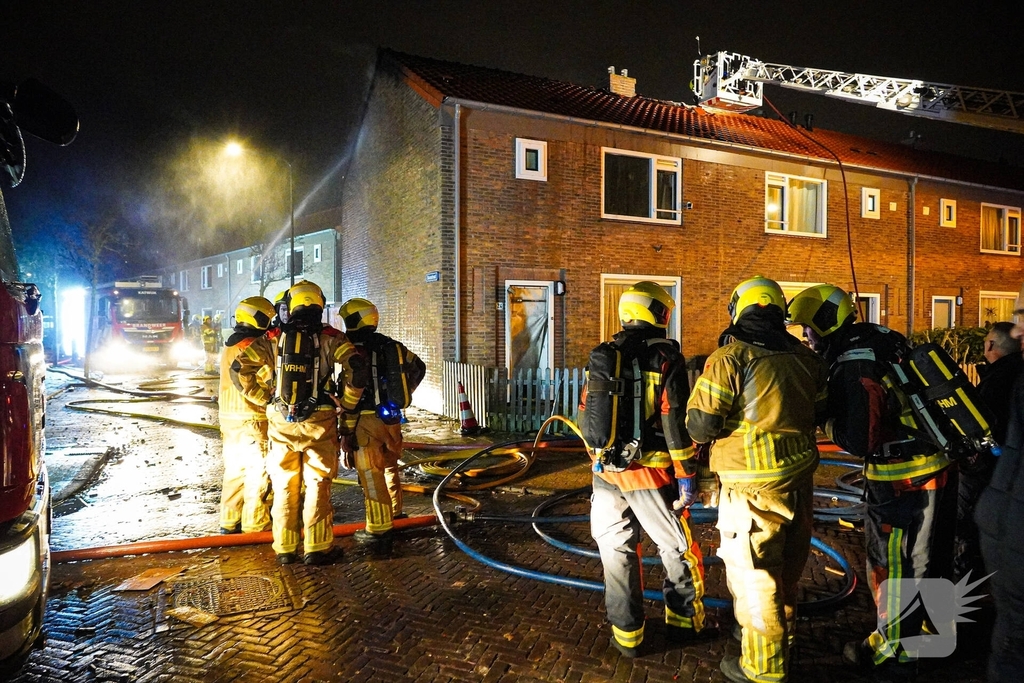 Rookwolken stijgen uit dak van woning