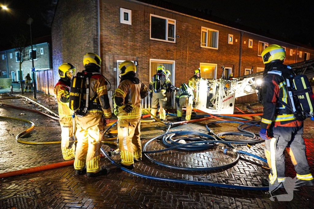 Rookwolken stijgen uit dak van woning
