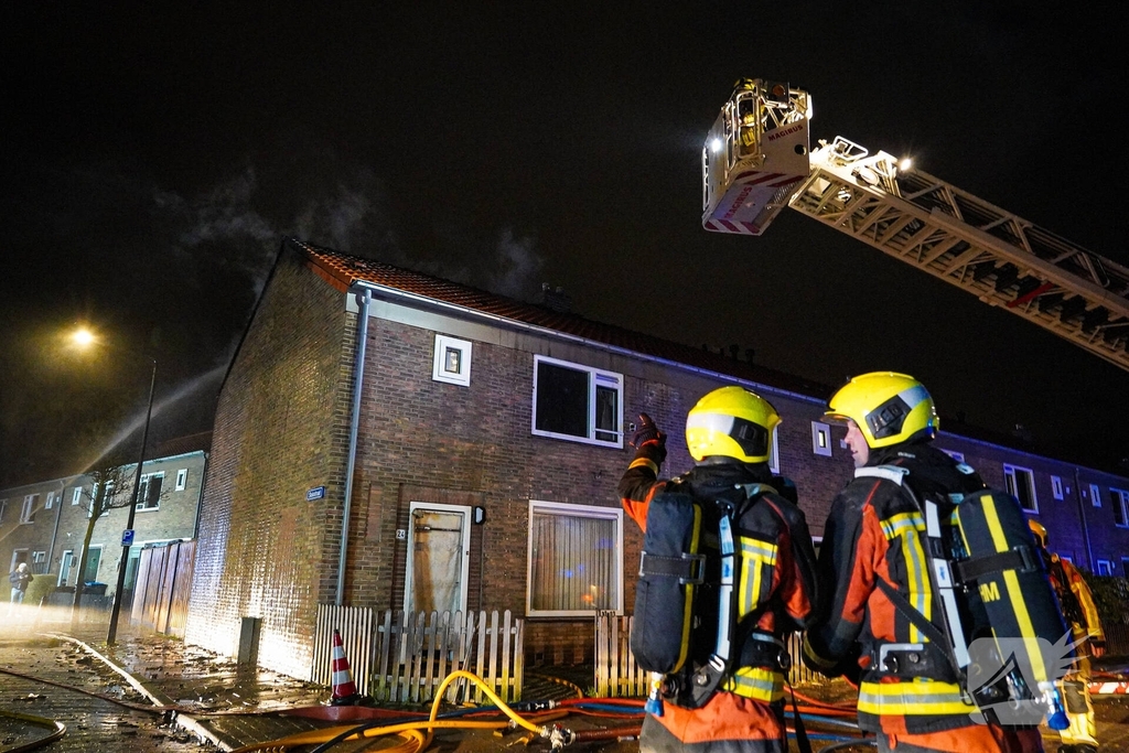 Rookwolken stijgen uit dak van woning