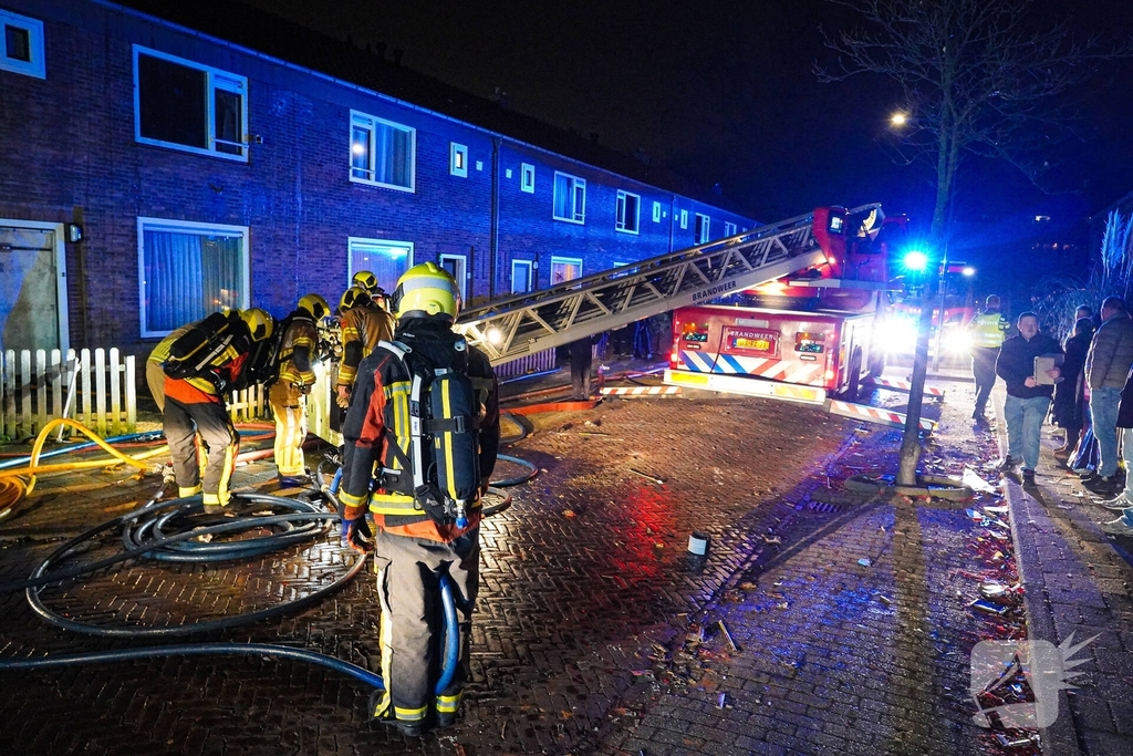 Rookwolken stijgen uit dak van woning