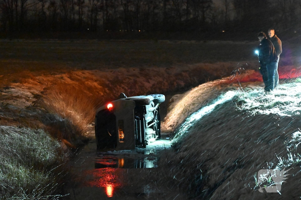 Auto belandt op zijkant in ondiepe sloot