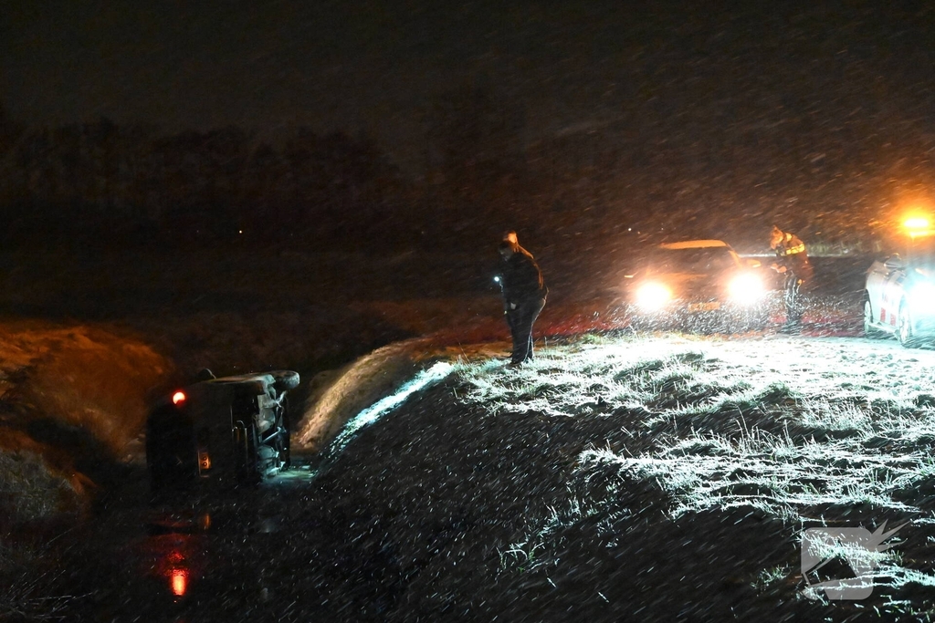 Auto belandt op zijkant in ondiepe sloot