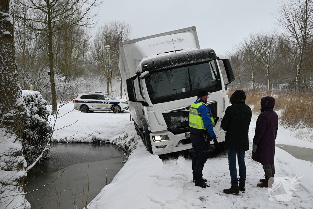 Vrachtwagen komt tot stilstand boven sloot