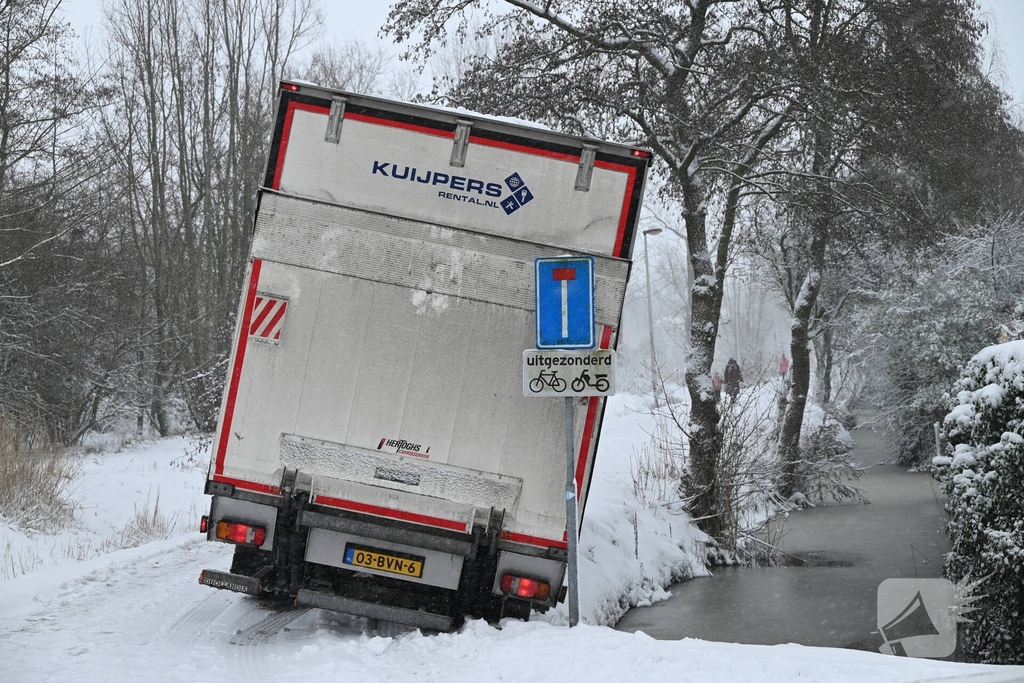 Vrachtwagen komt tot stilstand boven sloot