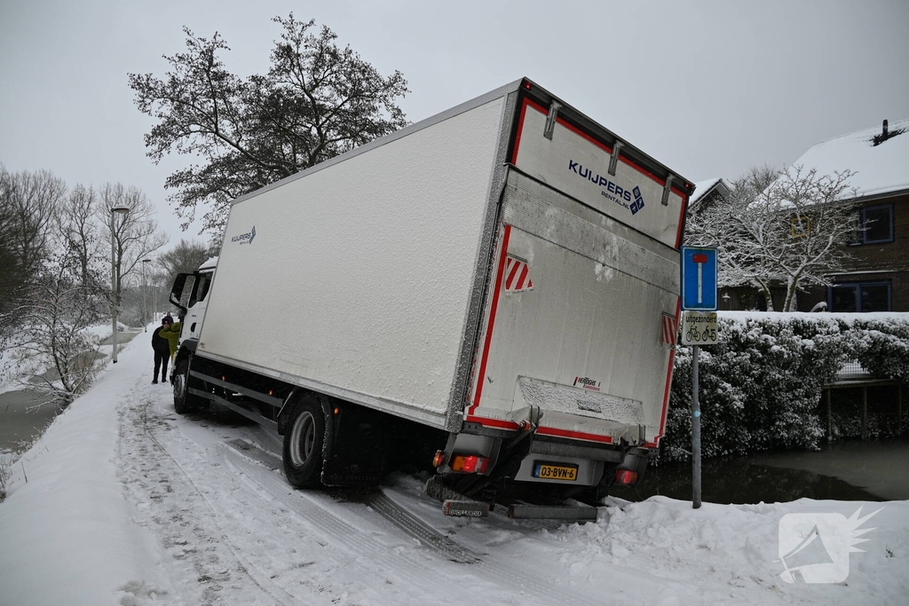 Vrachtwagen komt tot stilstand boven sloot