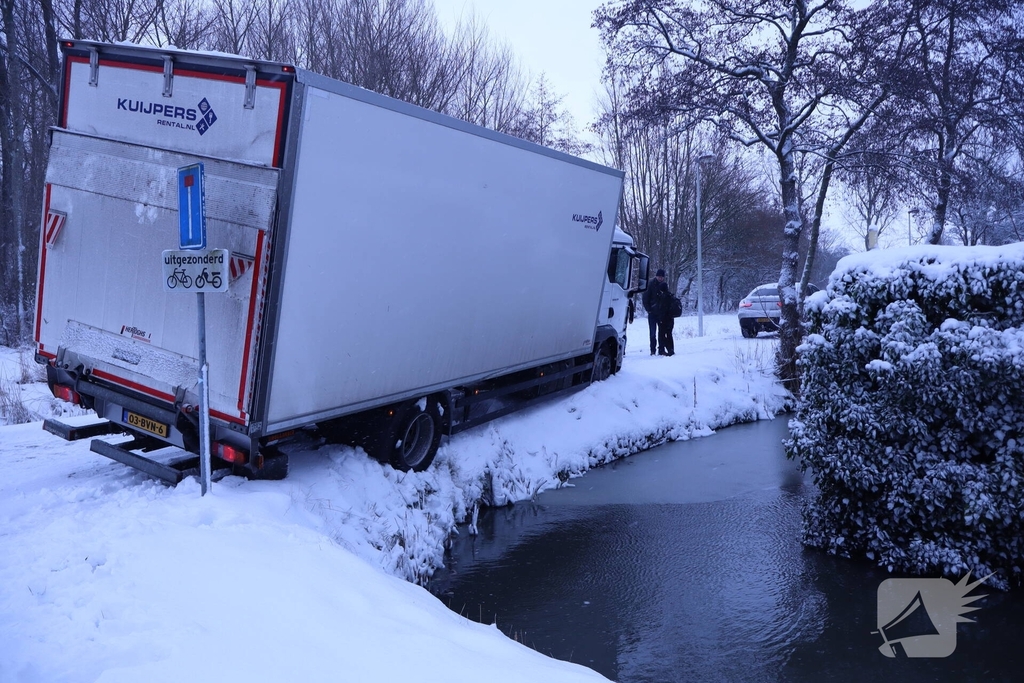 Vrachtwagen komt tot stilstand boven sloot