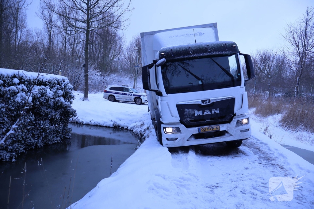Vrachtwagen komt tot stilstand boven sloot