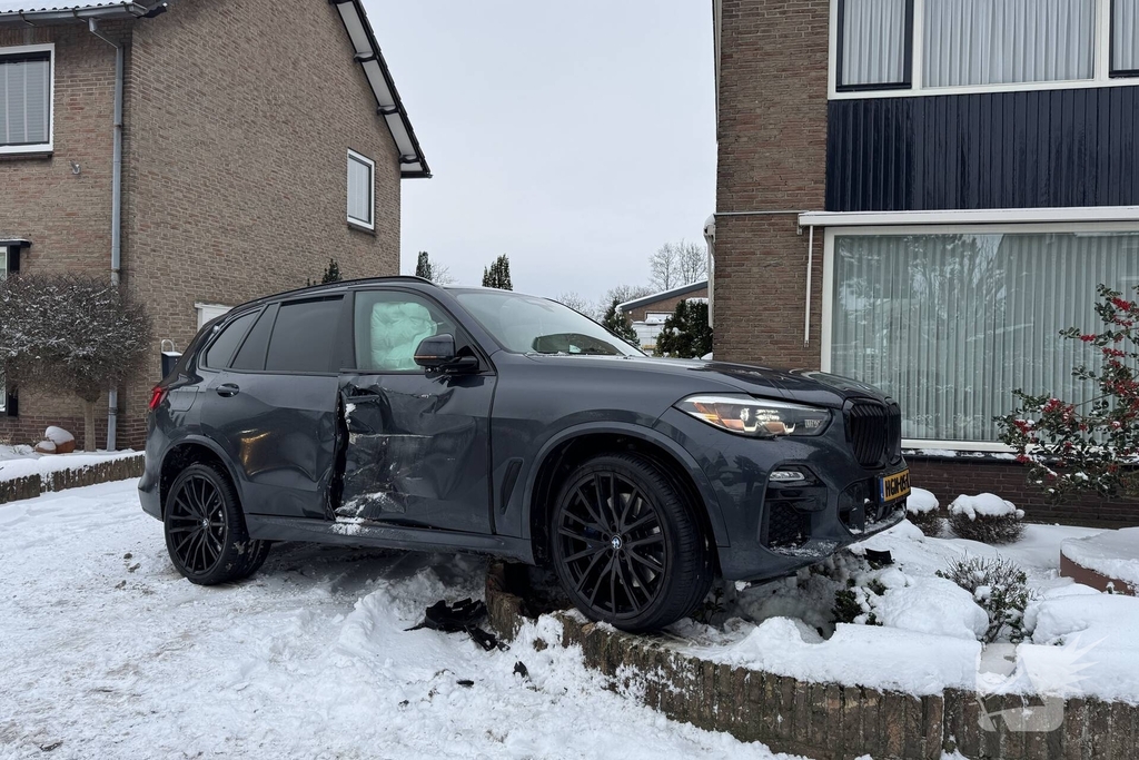 BMW crasht in voortuin na botsing