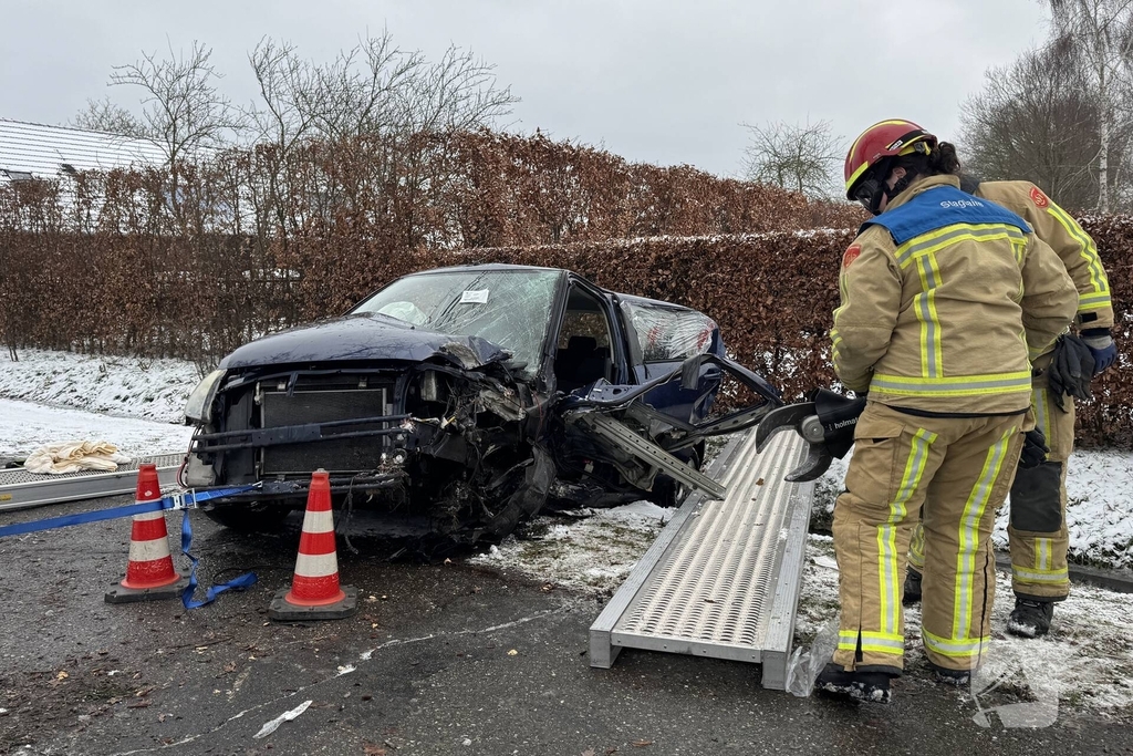 Brandweer bevrijdt persoon uit auto, omstander schiet te hulp
