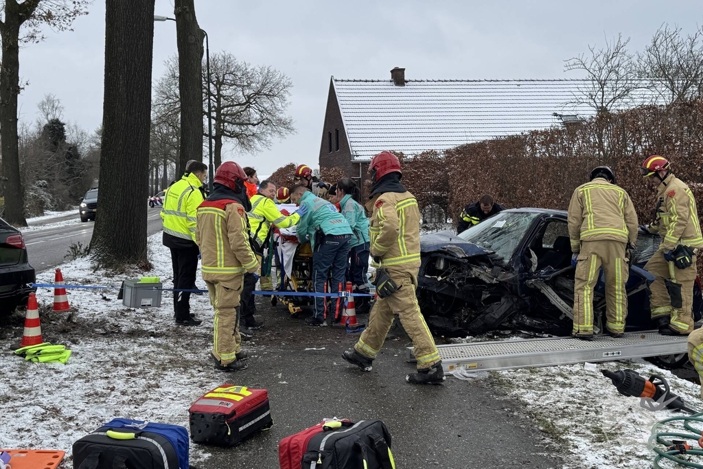 Brandweer bevrijdt persoon uit auto, omstander schiet te hulp