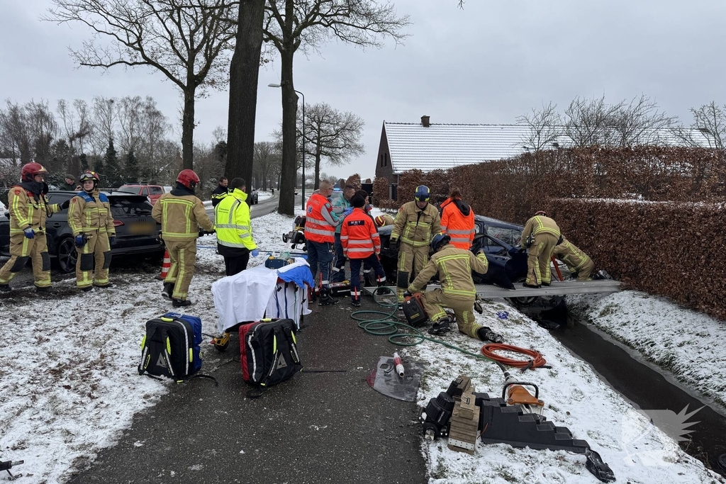 Brandweer bevrijdt persoon uit auto, omstander schiet te hulp