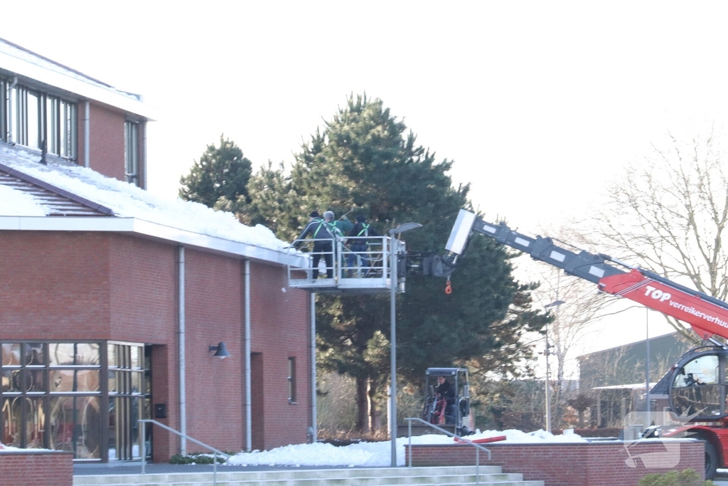 Dak van kerk sneeuwvrij gemaakt