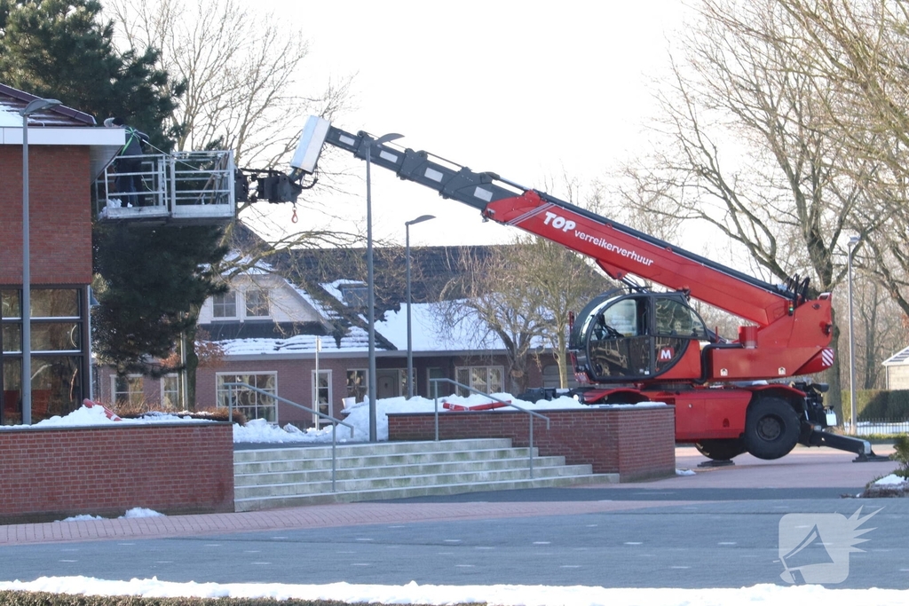 Dak van kerk sneeuwvrij gemaakt