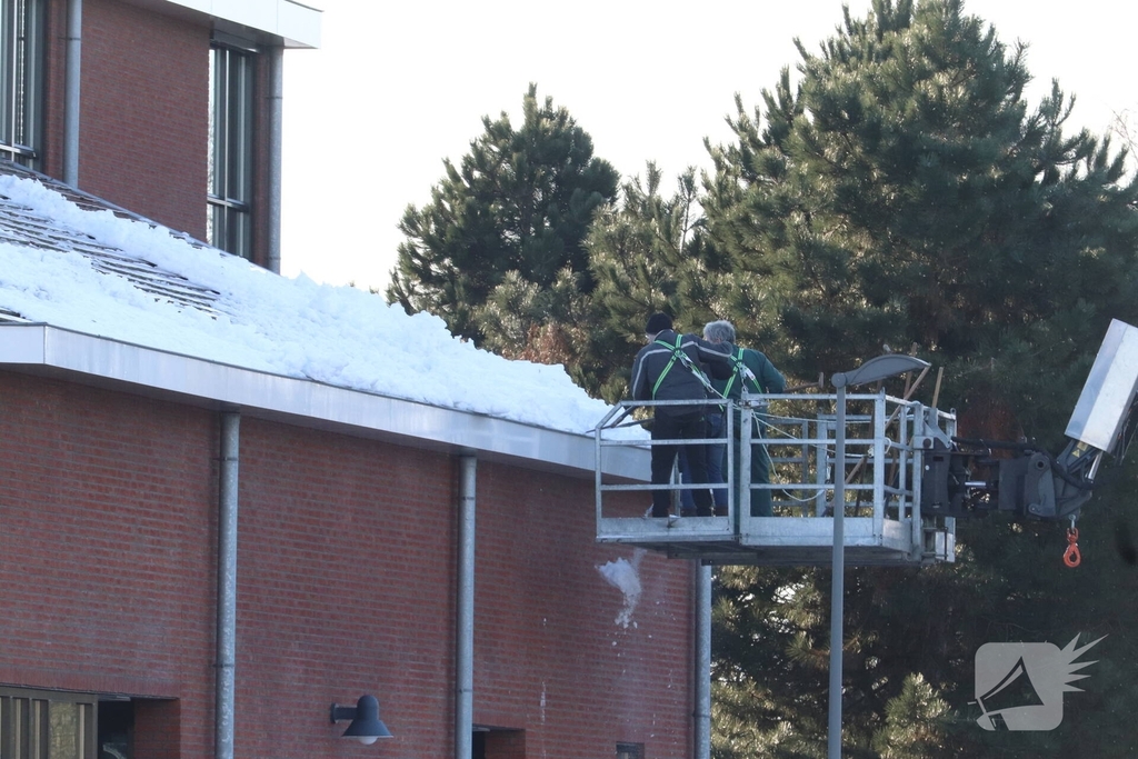 Dak van kerk sneeuwvrij gemaakt