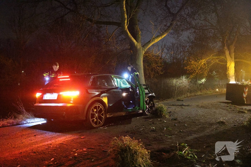 Auto botst tegen verkeersplaten