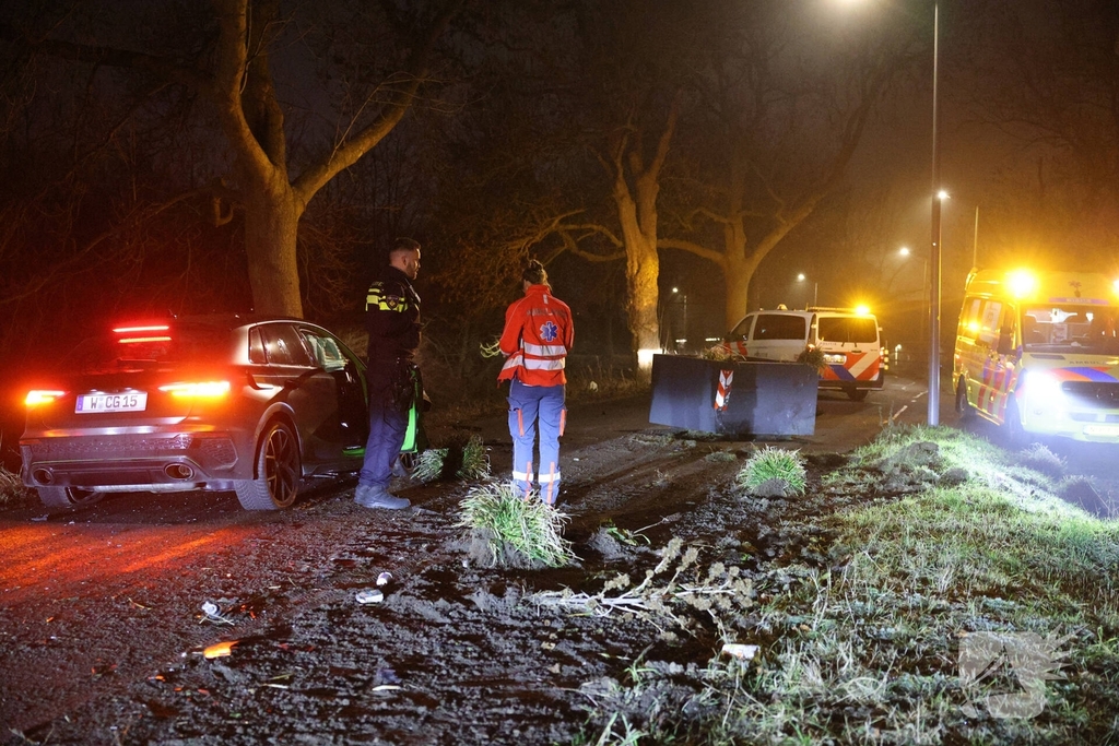 Auto botst tegen verkeersplaten