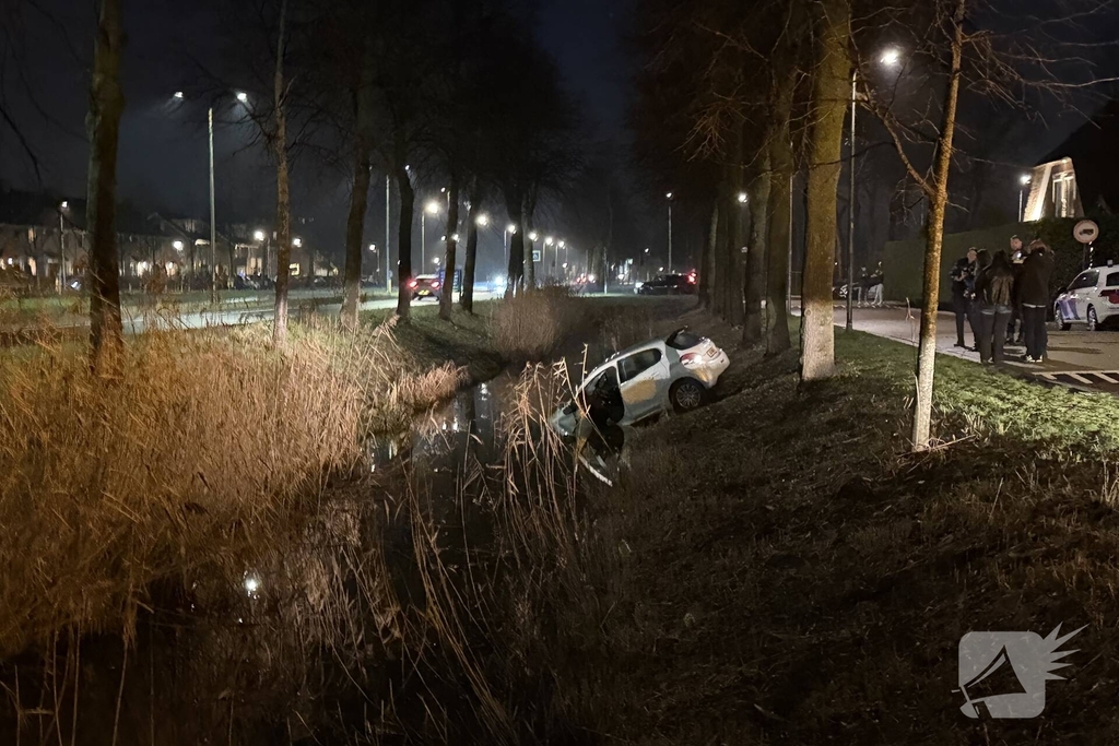 Personenauto belandt deels in water