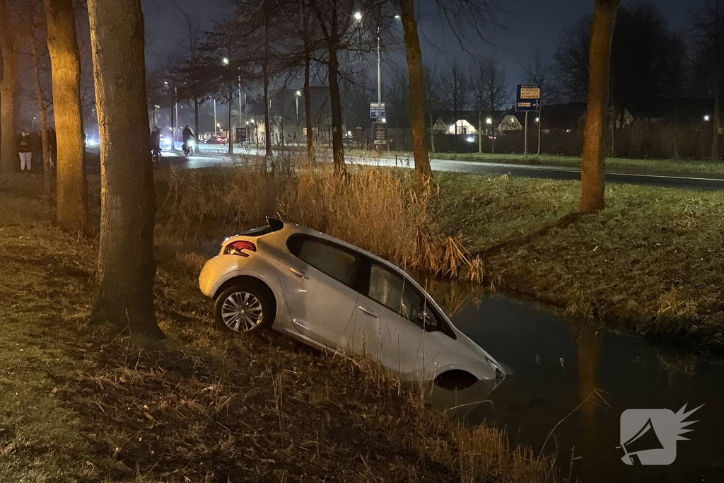 Personenauto belandt deels in water