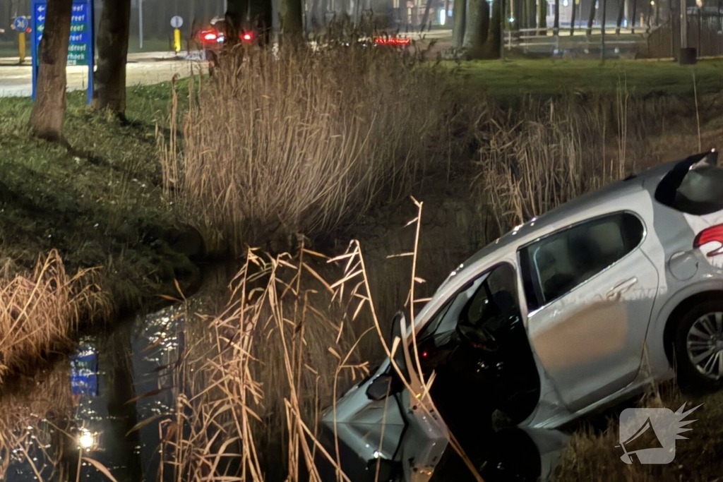 Personenauto belandt deels in water