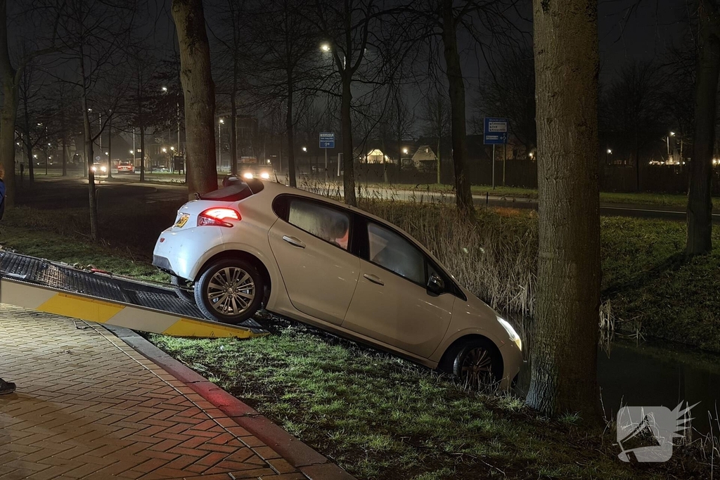 Personenauto belandt deels in water
