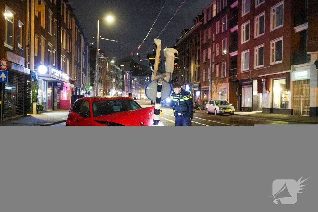 Auto rijdt stoplicht omver op druk kruispunt