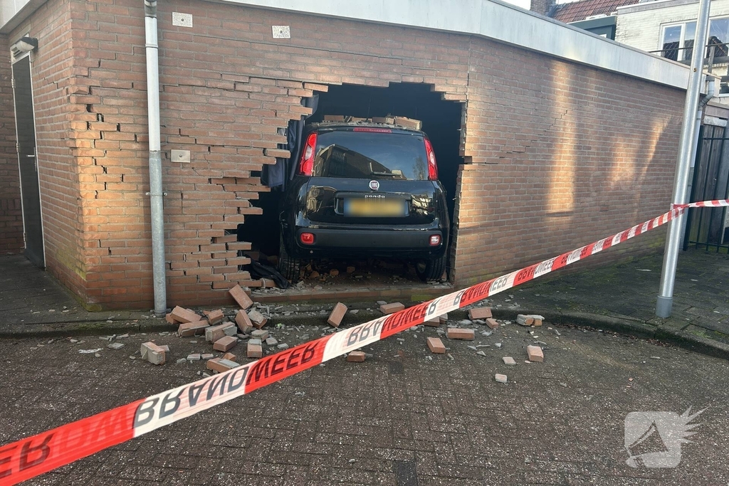 Vrouw rijdt dwars door muur van schuur