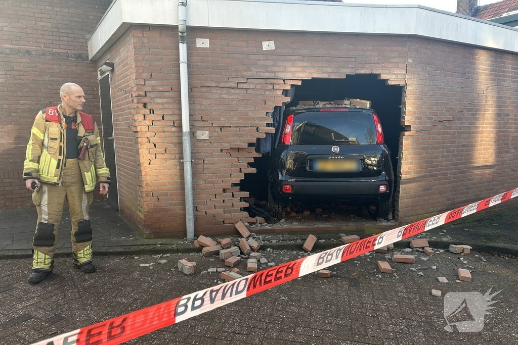Vrouw rijdt dwars door muur van schuur