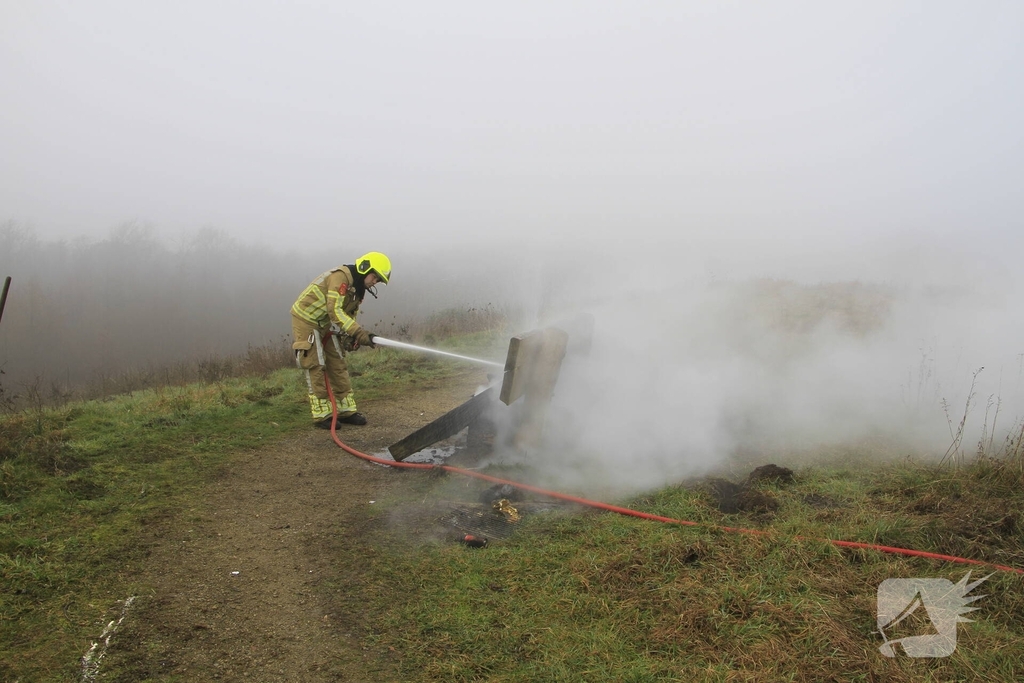 Buitenbrand onder monumentale bank na barbecue