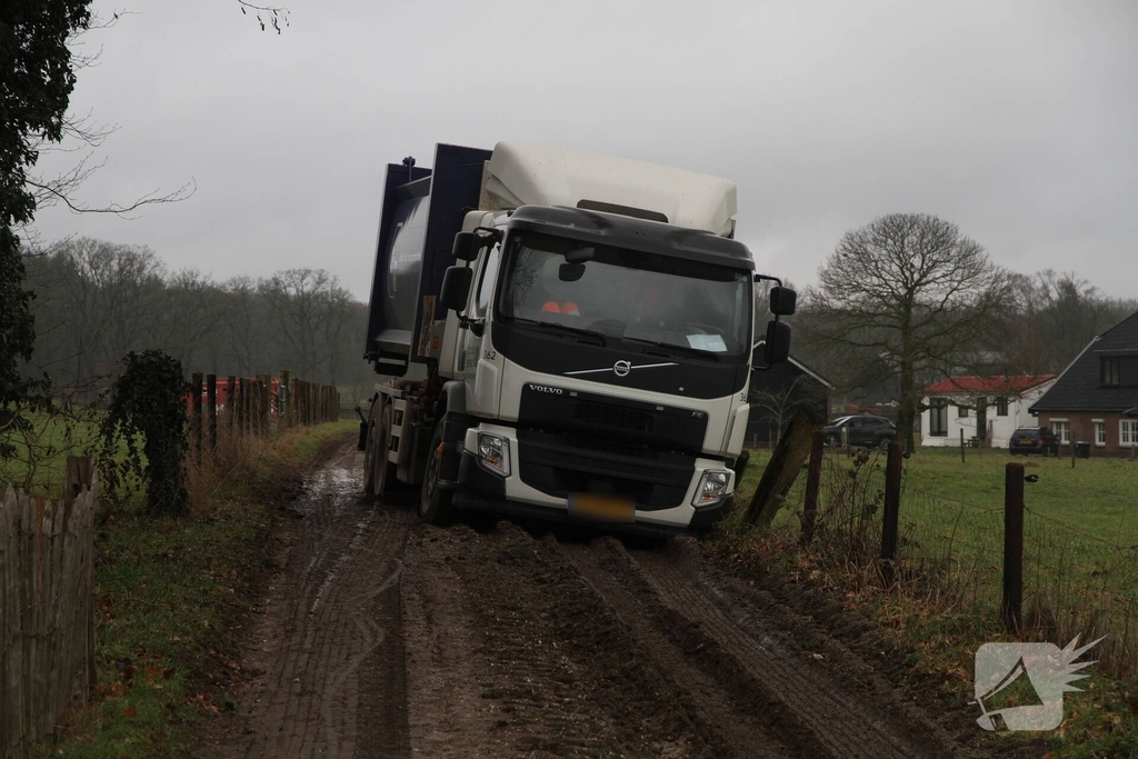 Vuilniswagen raakt paal en blijft vastzitten