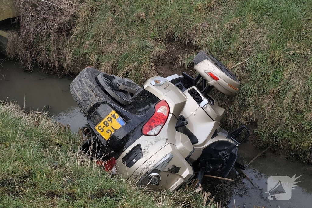 Motor met zijspan in sloot geëindigd