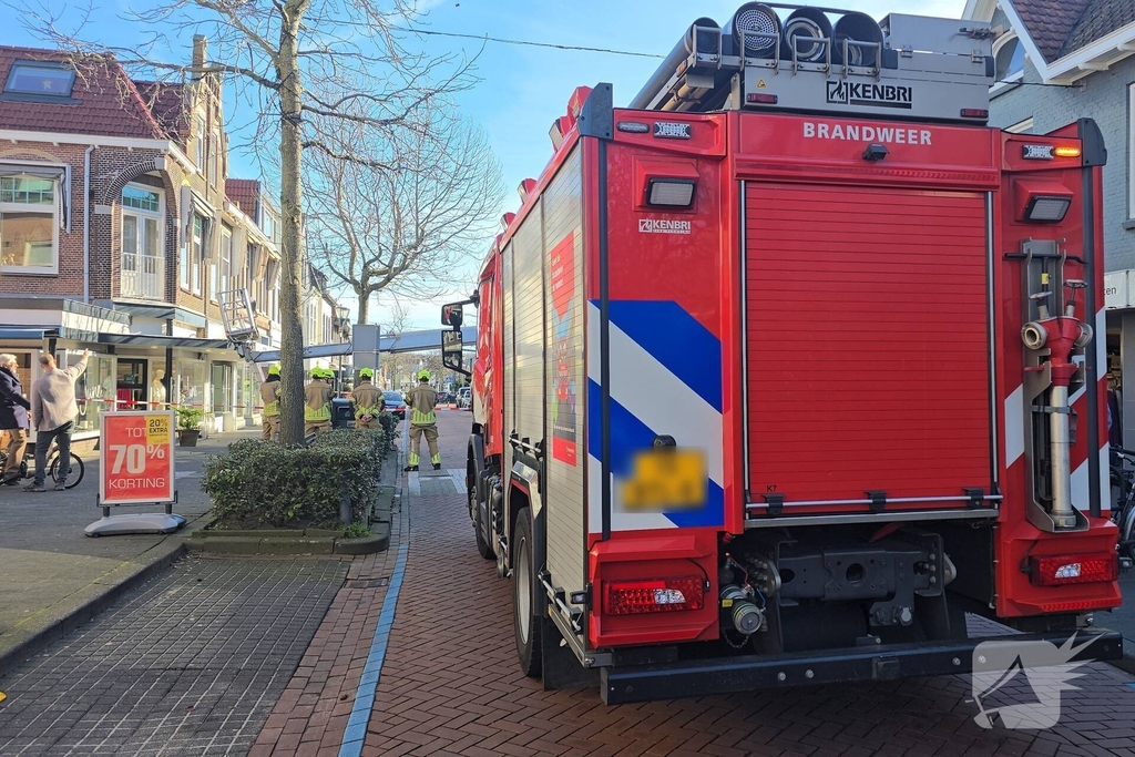 Hoogwerker kantelt tegen winkelpand