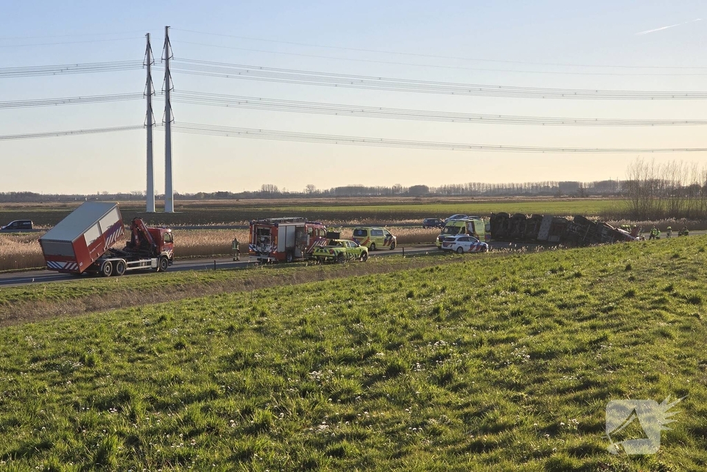 Vrachtwagen met betonblokken kantelt