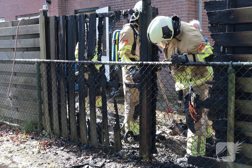 Brand in afvalbakken slaat over naar schutting
