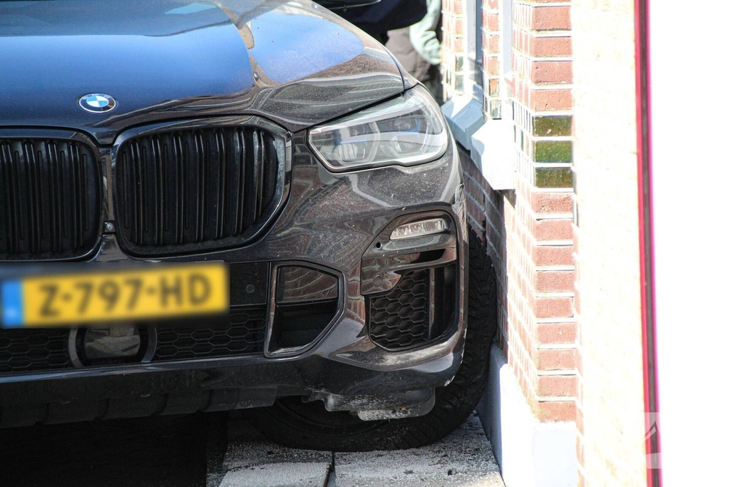 Auto botst tegen woning na aanrijding met paal