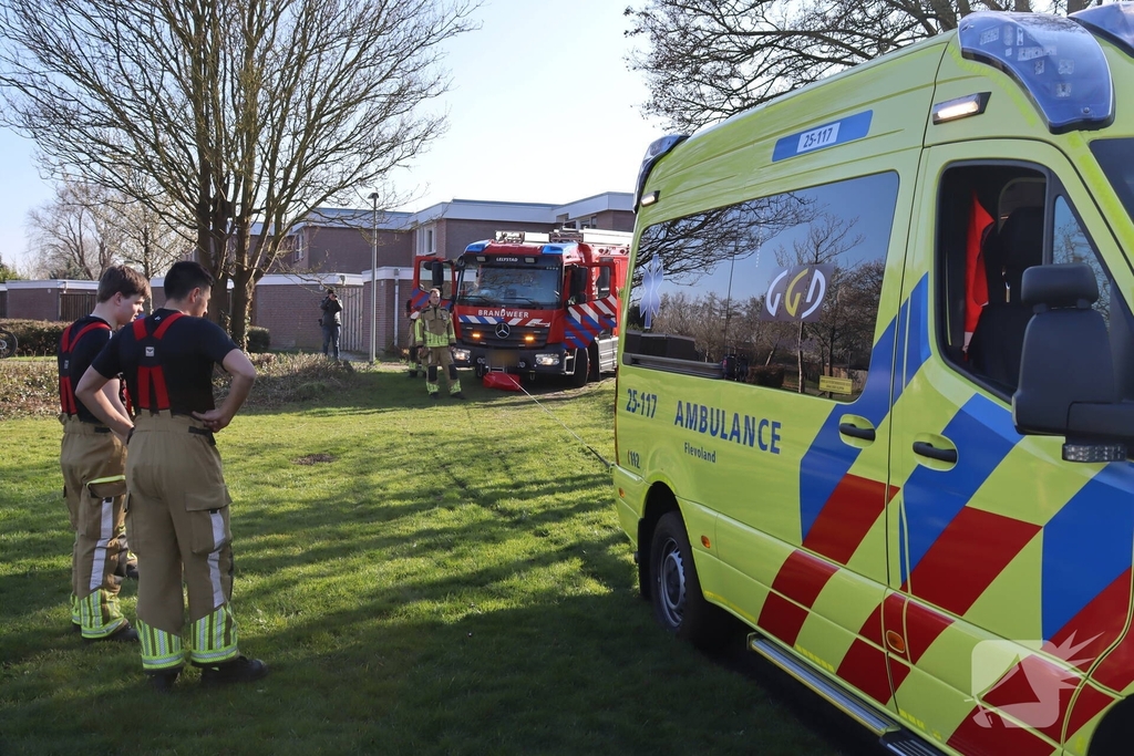 Ambulance vast in het gras, brandweer schiet te hulp