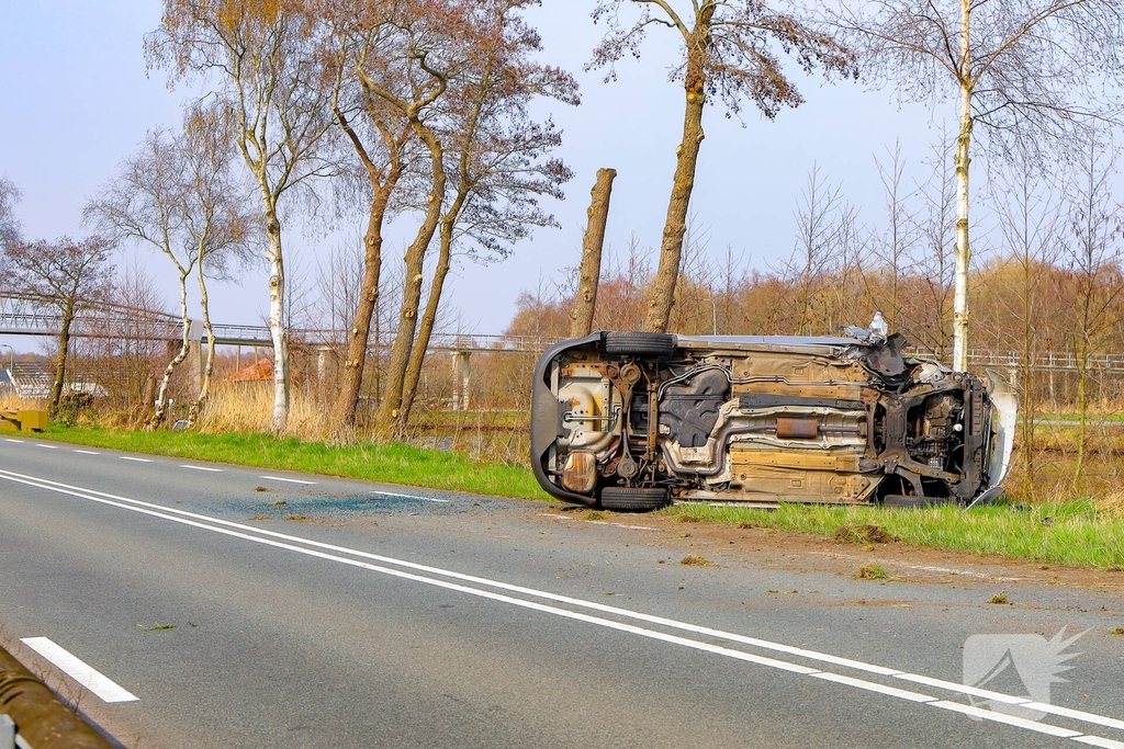 Auto belandt op zijn kant na botsing met boom