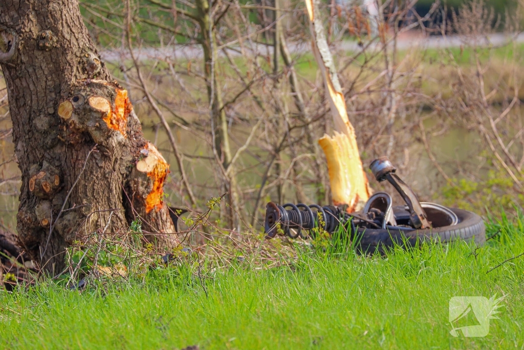 Auto belandt op zijn kant na botsing met boom