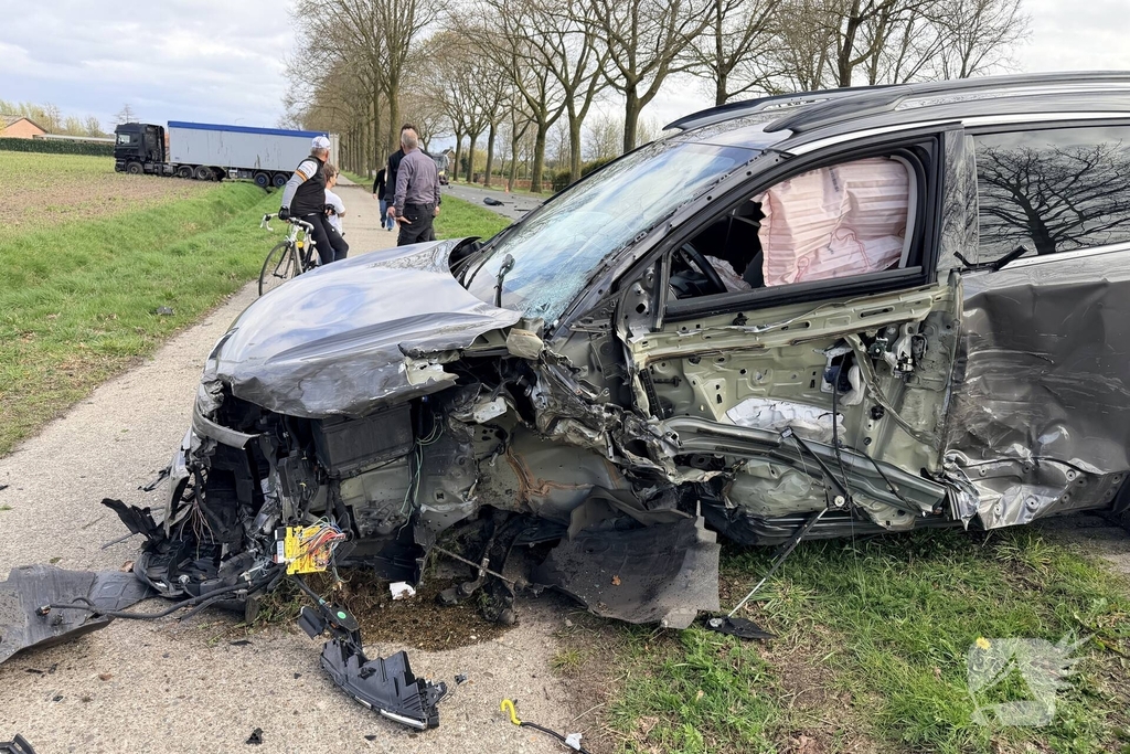 Vrachtwagen ramt auto en belandt in weiland