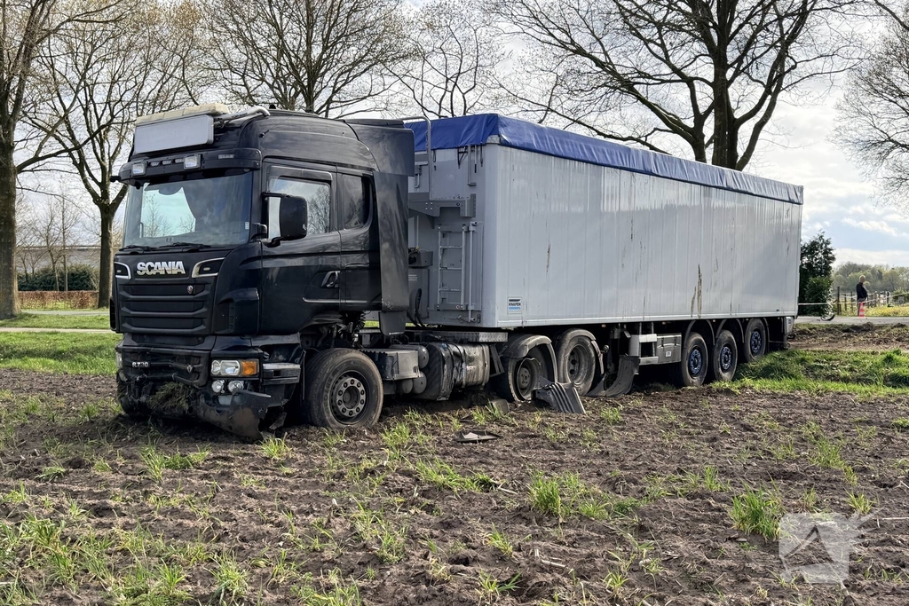 Vrachtwagen ramt auto en belandt in weiland