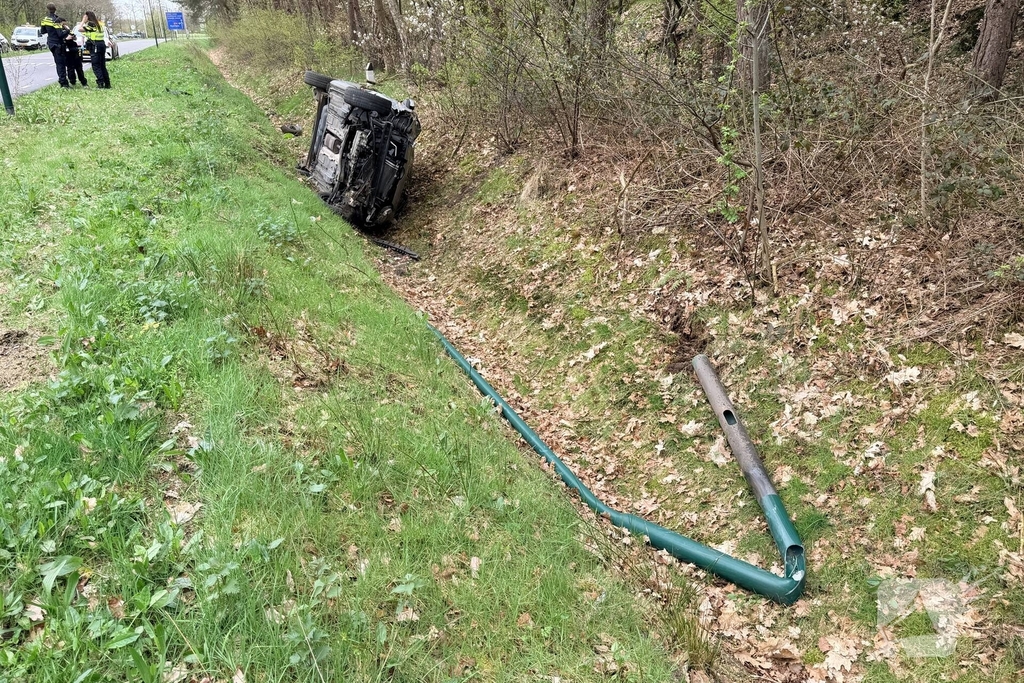 Auto belandt in sloot na aanrijding met lantaarnpaal
