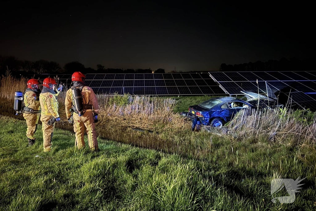 Auto boort zich in zonnepanelen na botsing met taxi