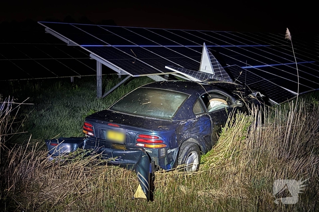 Auto boort zich in zonnepanelen na botsing met taxi