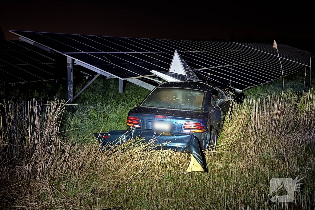 Auto boort zich in zonnepanelen na botsing met taxi